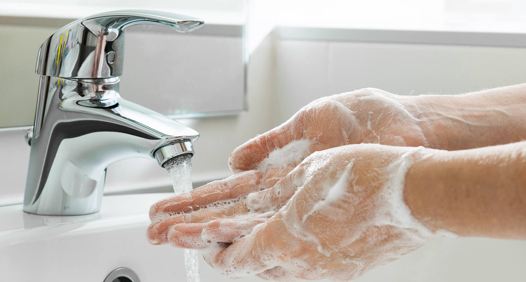 se lave les mains avec du savon dans l'évier